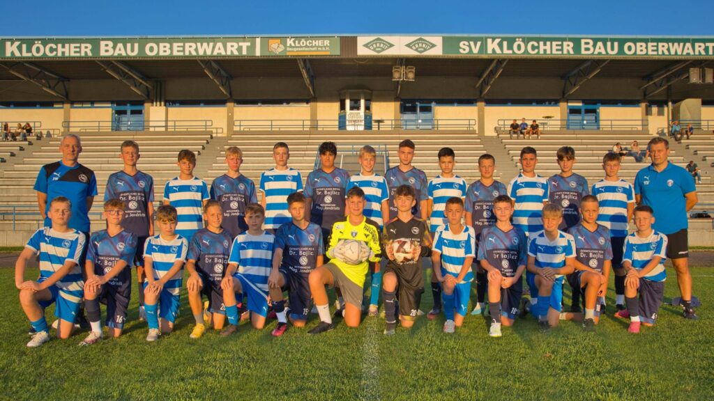 Jugendfußballmannschaft des SV Klöcher Bau Oberwart im Teamfoto im Stadion, alle in blauen Trikots.