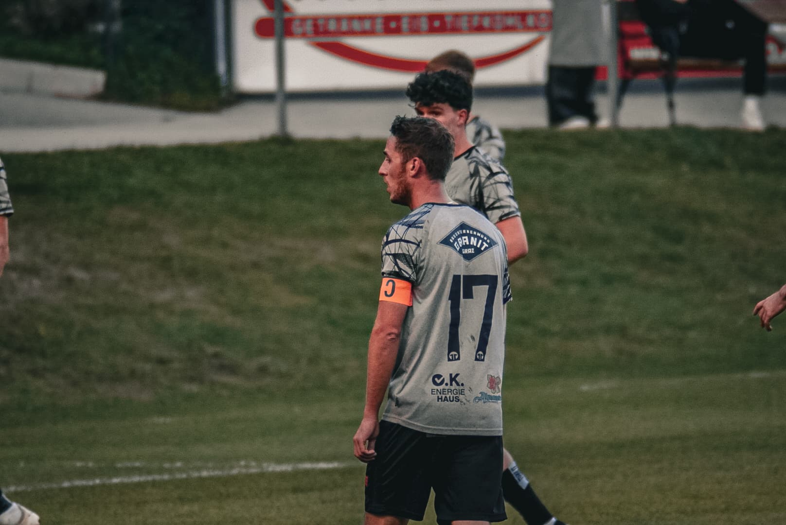 Fußballspieler mit der Nummer 17 im grauen Trikot auf dem Spielfeld, trägt eine Kapitänsbinde.