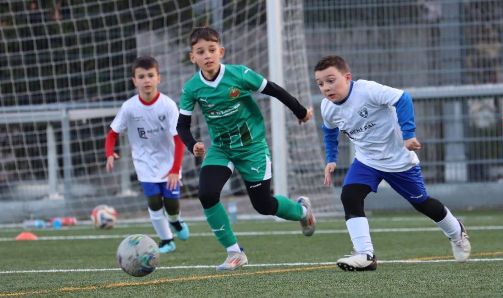 Kinder spielen Fußball auf einem Feld, voller Energie und Begeisterung. Training und Teamarbeit für junge Sportler.