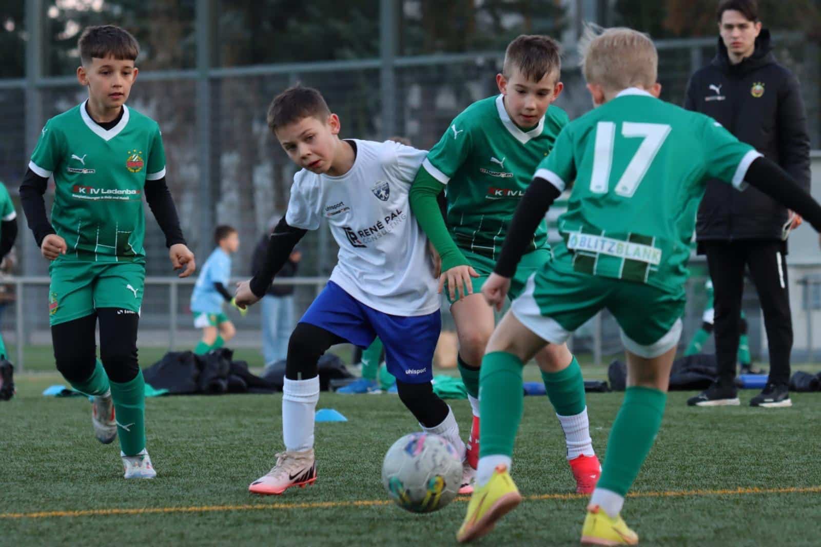 Kinder spielen Fußball auf dem Feld, konzentriert und voller Energie im Teamgeist.