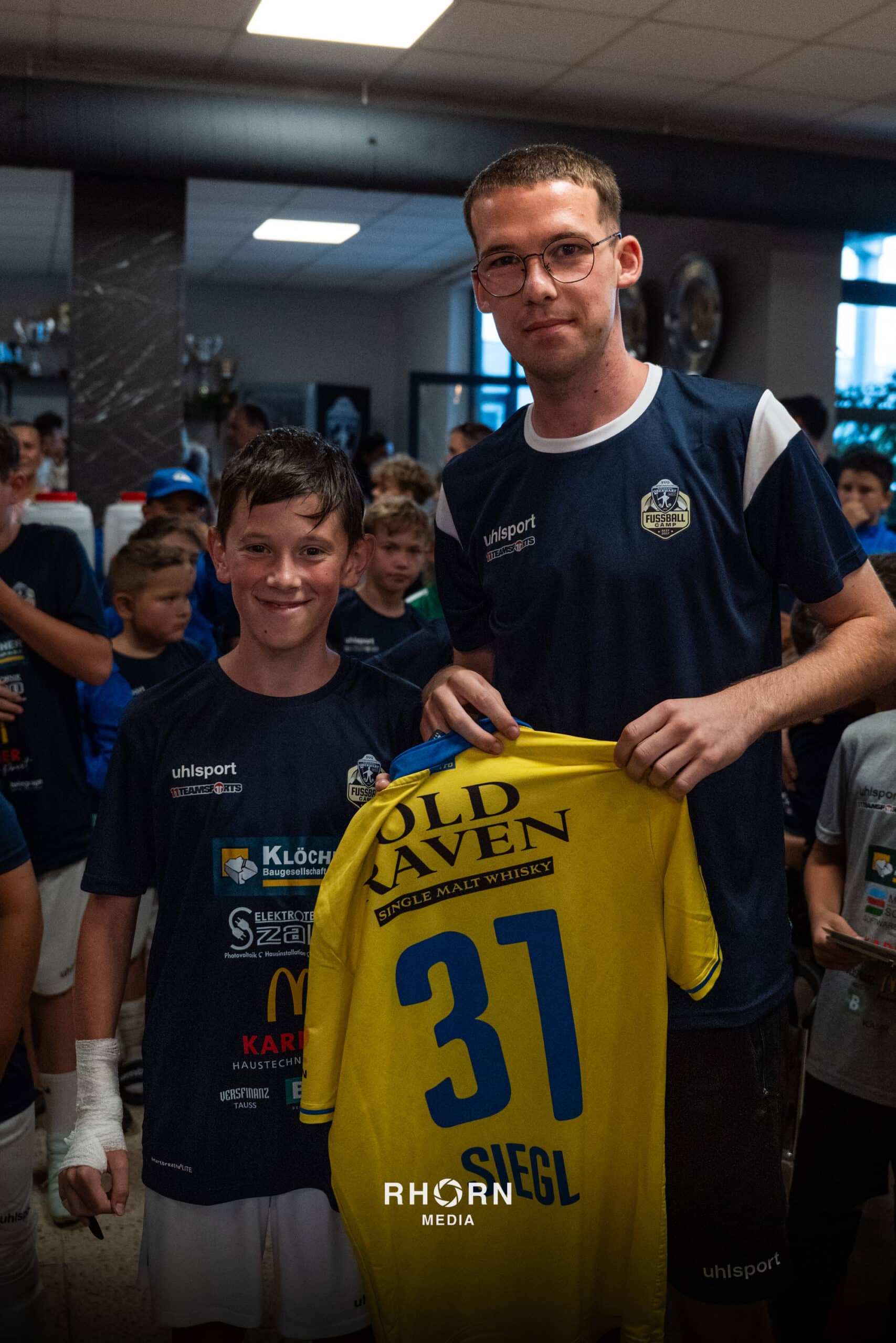 Jugendfußballer mit gelbem Siegl-Trikot bei einem Event im Vereinsheim, von Rhrhorn Media fotografiert.