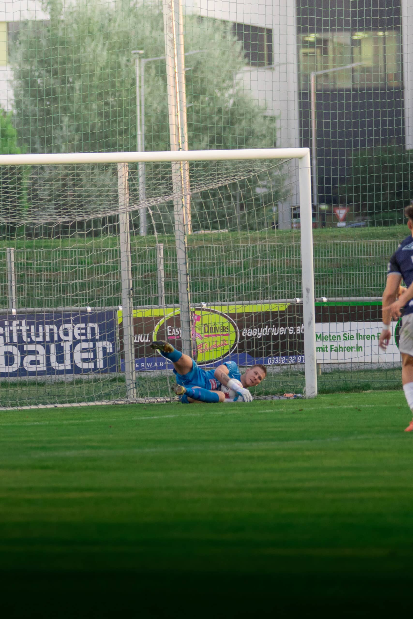 Torwart rettet den Ball auf der Torlinie während eines Fußballspiels im Stadion, dynamische Actionaufnahme.
